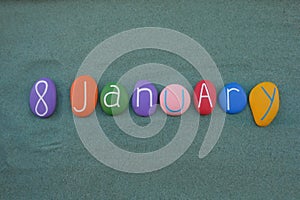 8 January,Â calendar date composed with multi colored stones over green sand